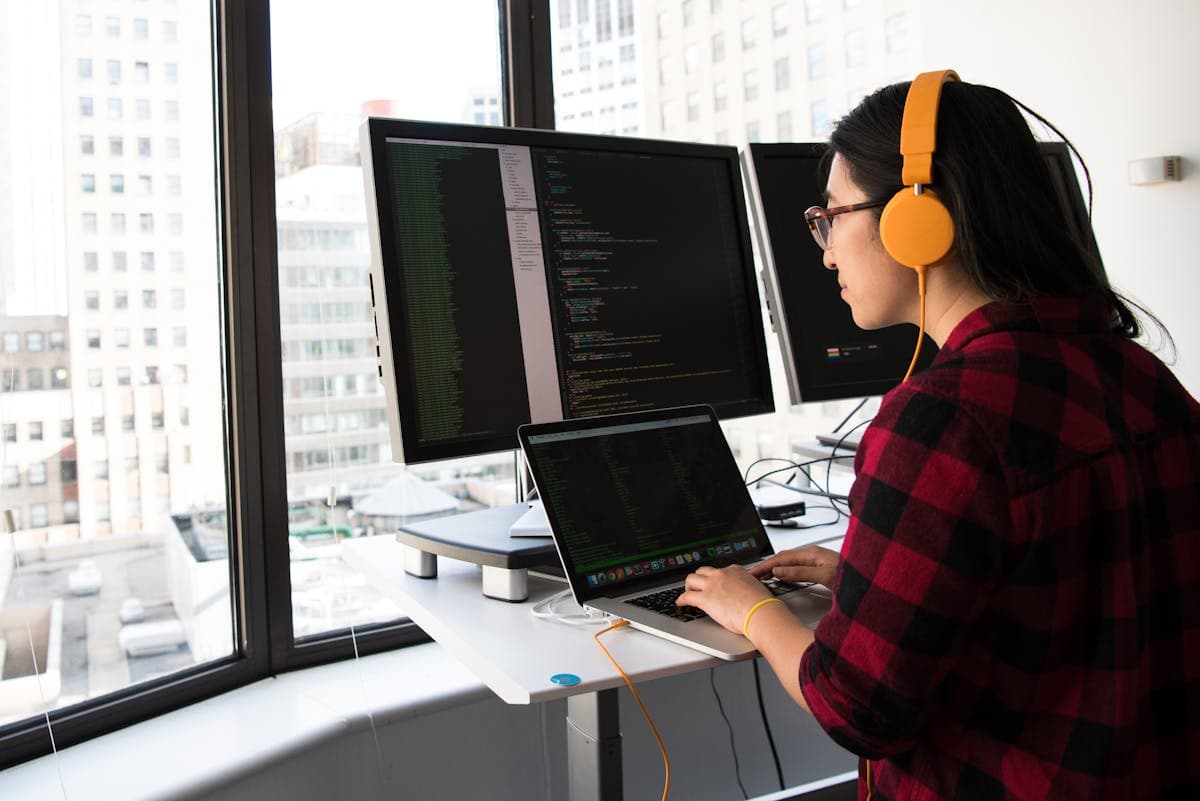 Developer writing code on multiple monitors